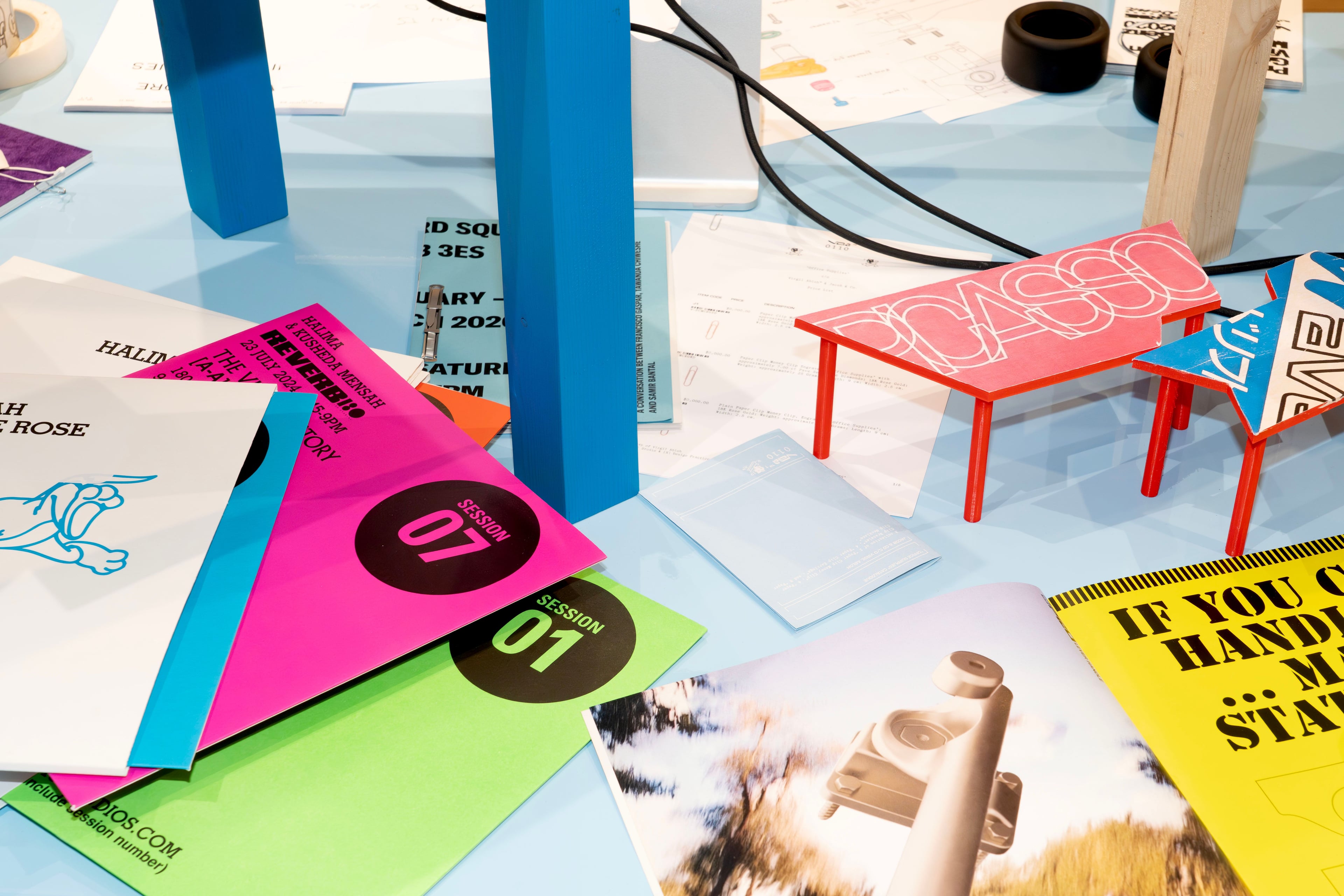 Printed materials and prototypes on a blue tabletop.