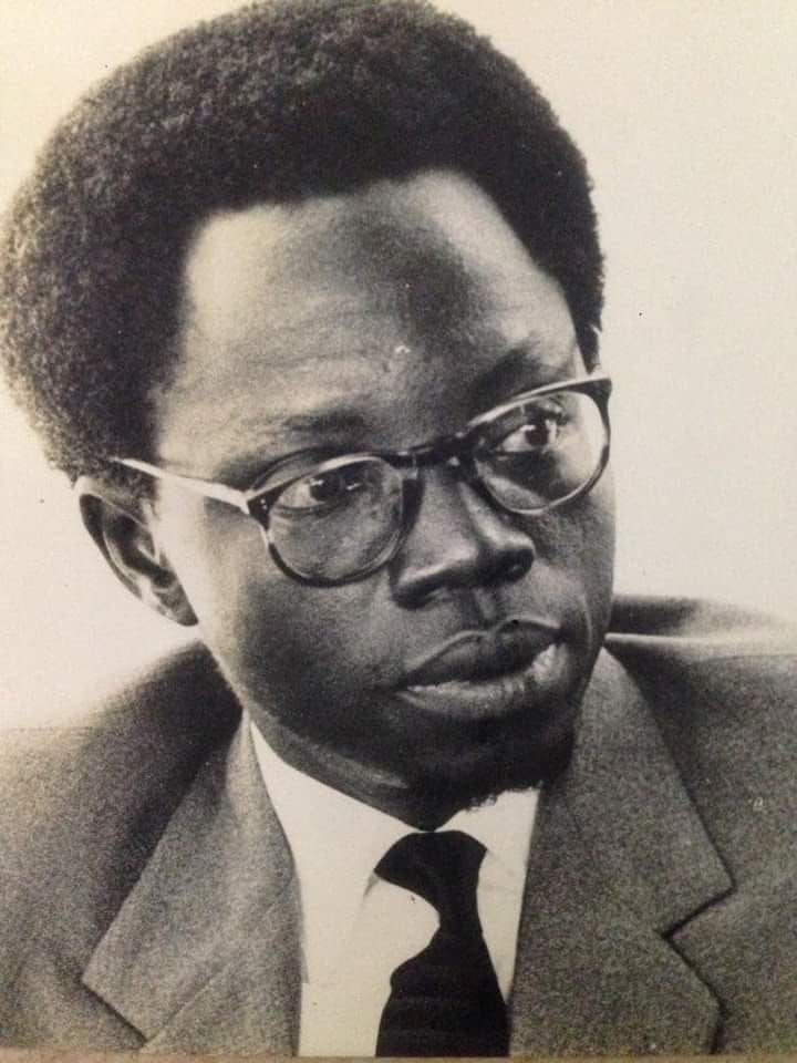 A man with glasses and dark, curly hair looks intently to the right.