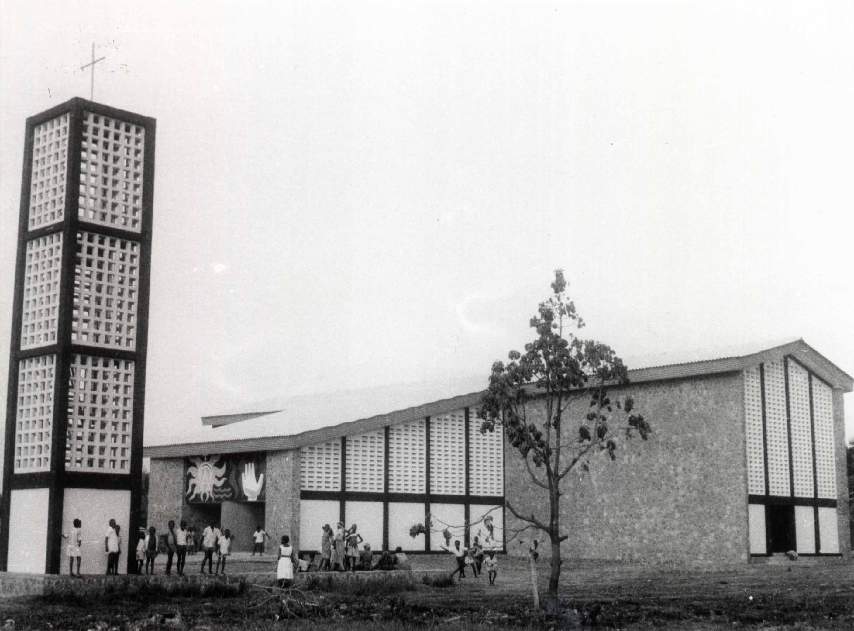 Modernist church with a tall, open bell tower and large glass windows.
