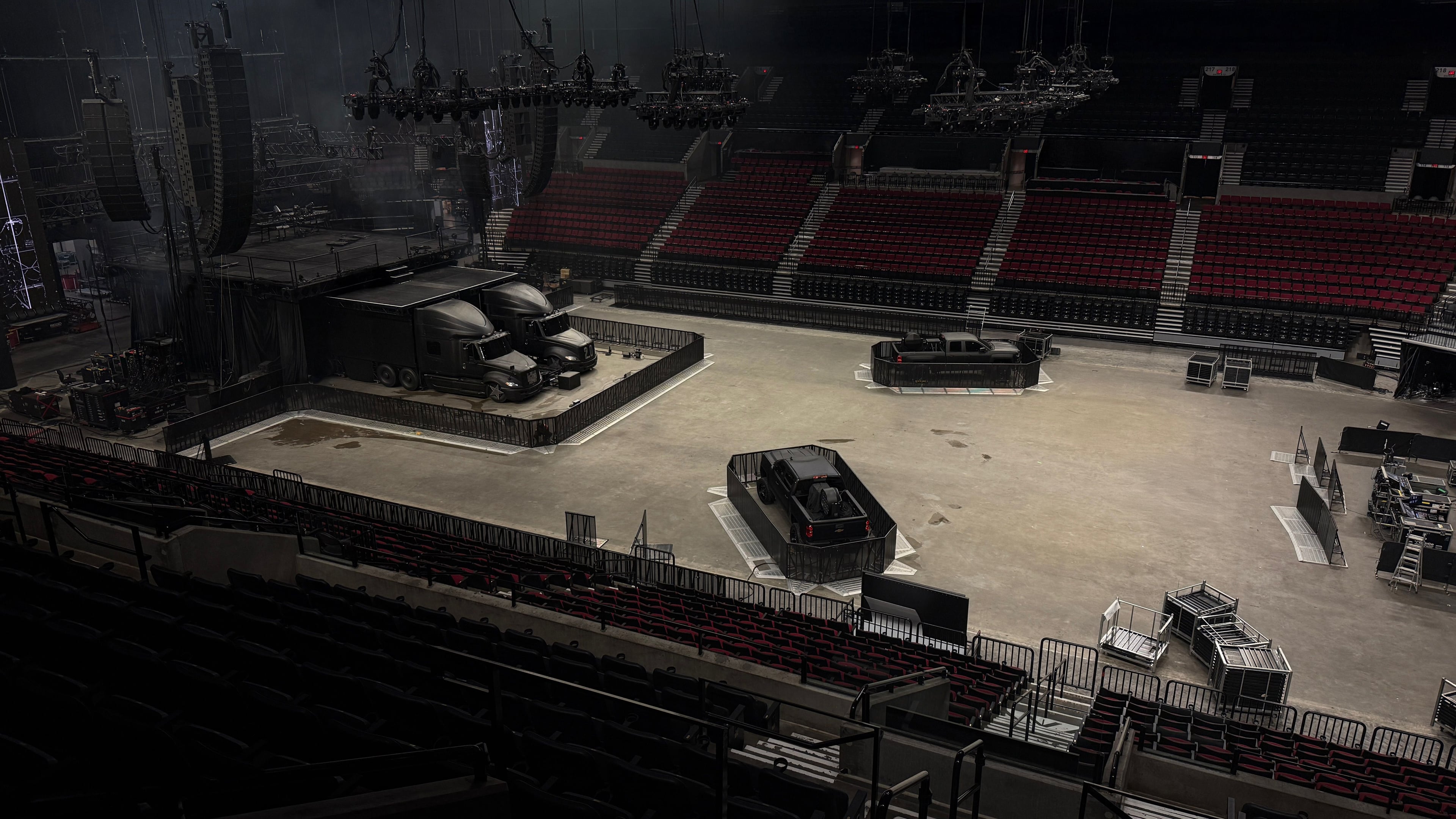 Photograph showing an empty venue with a stage featuring the two trucks