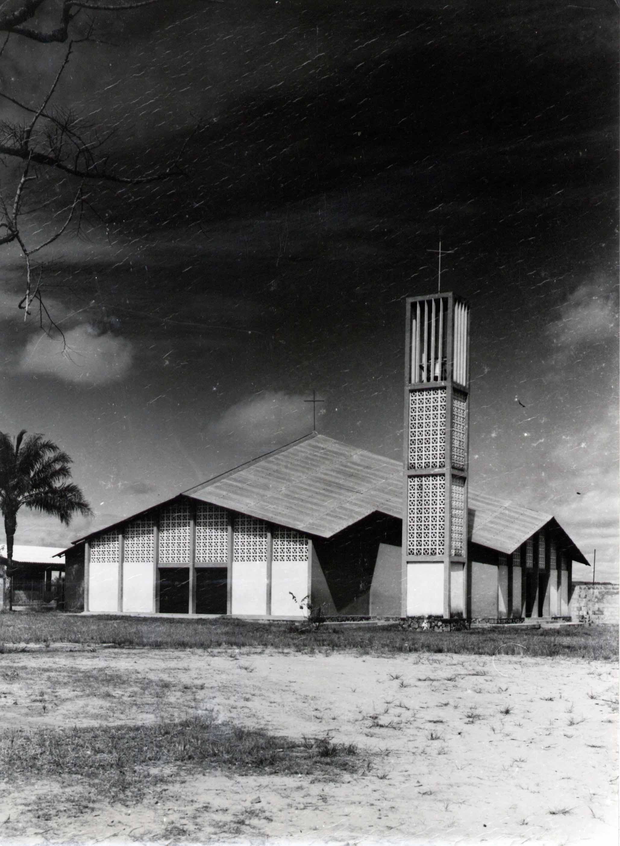 Modernist church building with a tall, square bell tower and a sloping roof.