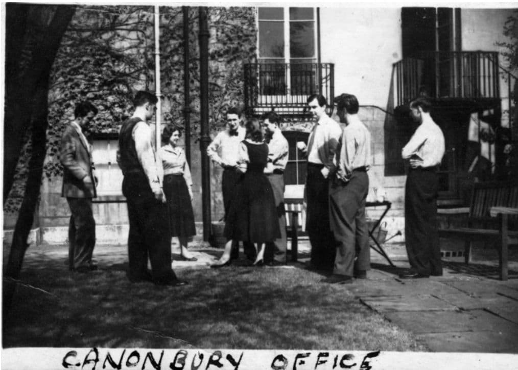 A group of young adults gathered casually outdoors near a building, possibly the Canonbury office.